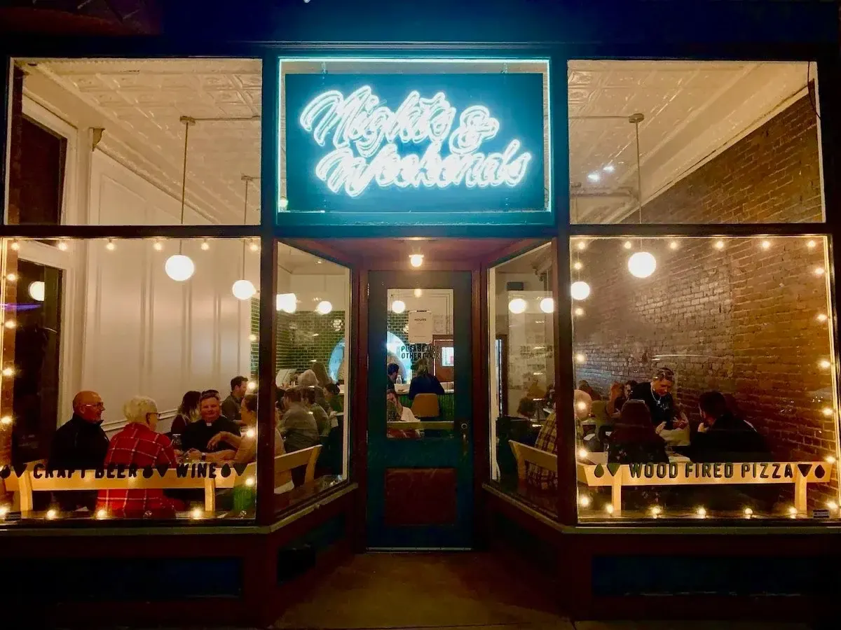 The Nights & Weekends storefront on Bridge Street at night